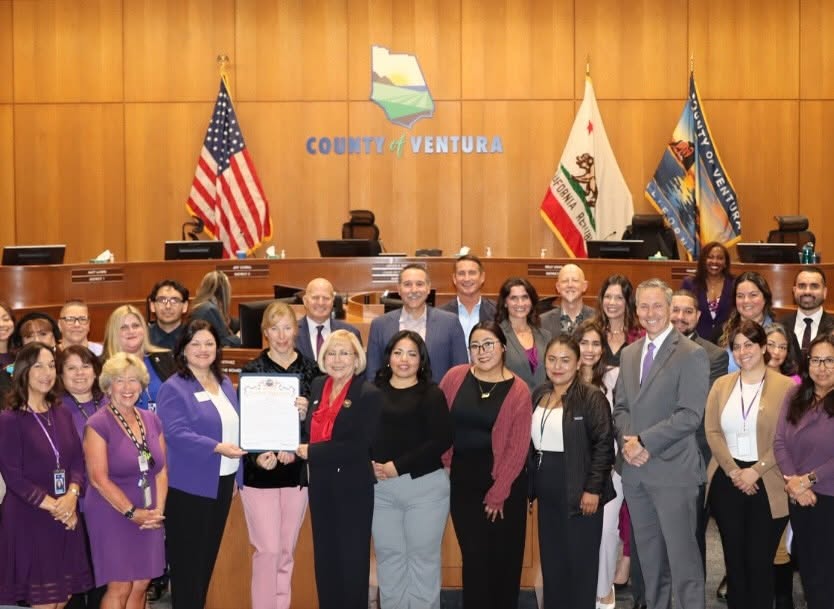 Coalition staff and county leaders with a Domestic Violence Awareness Month proclamation